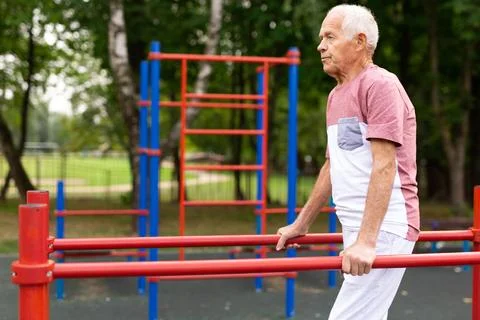 Senior man performing parallel bar exercises in park Stock-Fotos