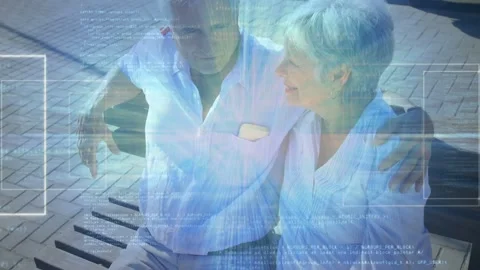 Senior man placing arm around woman on bench, sharing comfort while tech overlay Stock Footage 333145249