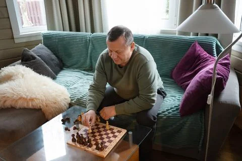 Senior man playing chess alone at home. Home Leisure Activities Stock Photos