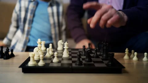 Senior man playing chess with smart little grandson, memory training at home Stock Footage 321359859