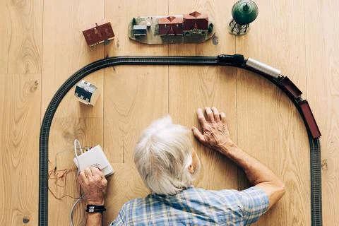 Senior Man Playing With Model Train Фото