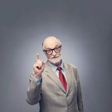 Senior man points finger up Stock Photos