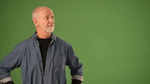 Senior Man Poses Against Solid Green Screen Background for Product Announcement Stockfoto's