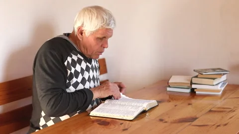 Senior man praying, reading an old Bible in his hands. Stock Footage 165172704