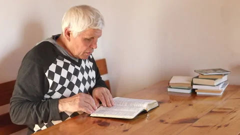 Senior man praying, reading an old Bible in his hands. Stock Footage 165172830