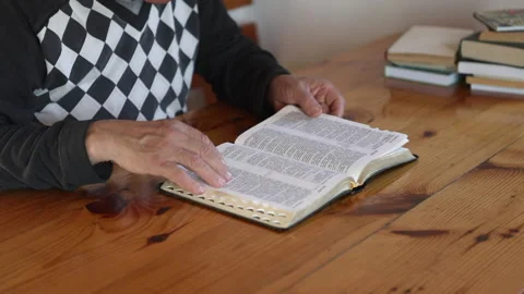 Senior man praying, reading an old Bible in his hands. Stock Footage 165172877