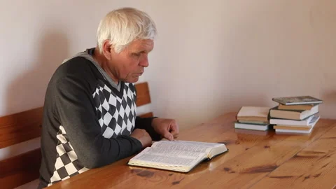 Senior man praying, reading an old Bible in his hands. Stock Footage 165173257