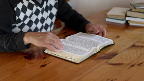 Senior man praying, reading an old Bible in his hands. Stock Footage 165173809