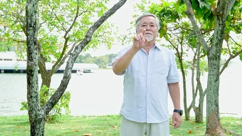 Senior man pressing button in park. Stock Footage 92283285