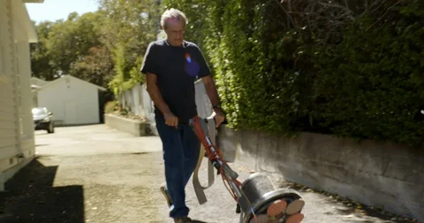 Senior man pushing a sander down a driveway. 스톡 동영상 88376054
