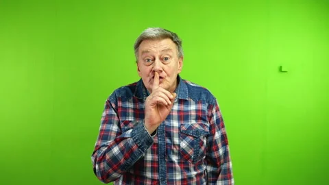 Senior man puts fingers to lips and says shhh demanding silence about secret. Stock Footage 249465152