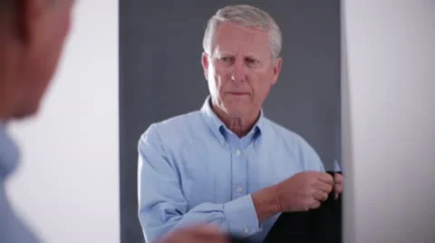 Senior Man Putting on Coat in front of Mirror Stock Footage 20464222