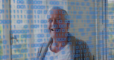 Senior man reacting to binary code overlay by turning head and smiling in Stock Footage 329580362