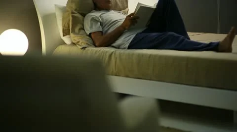 Senior man reading in bed; Full HD Photo JPEG Video stock 10608236