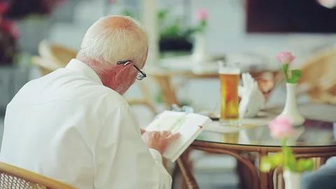 Senior man reading book in cafe Video stock 77887912