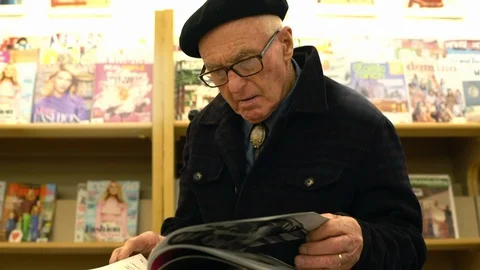 Senior man reading in a bookstore. Vidéo 88372354