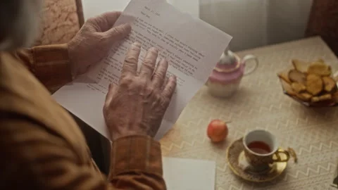 Senior Man Reading Nostalgic Letter from Family at Table Stock Footage 337575953