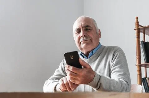 Senior man reading a text message on a mobile Stock Photos