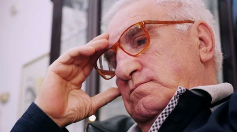 Senior man with red glasses thinks touching his forehead Stock Footage 63419557