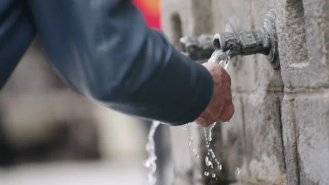 Senior man refreshing with water from an old tap outdoors, slow motion Video stock 277911284