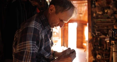 Senior man in regular workwear in the workshop repairs the clock. master repairs Stock Footage 127943731