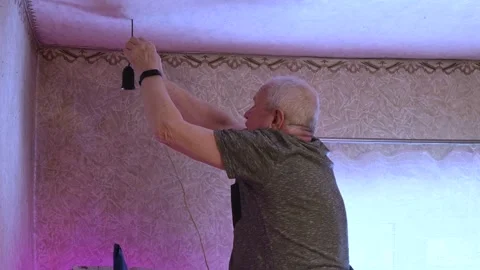 Senior Man Repairing Electrical Light Socket on Ceiling in Home Interior Stock Footage 332052982