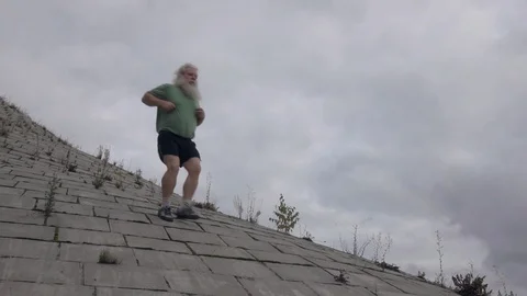 Senior man runs down on flagging downhill in slow motion Vídeos de archivo 122154335