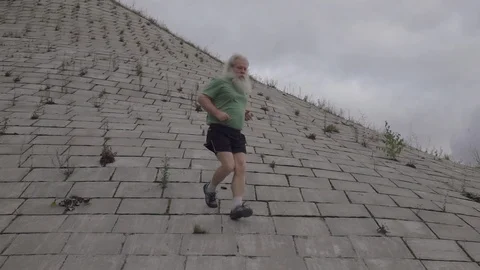 Senior man runs down on flagging downhill in slow motion 库存影片 122154341