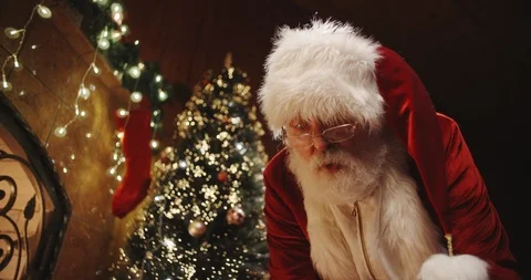 Senior man in santa clause costume leaving christmas presents in boxes near Stock Footage