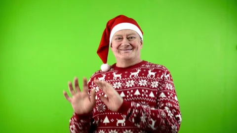 Senior man in Santa hat and Xmas sweater having fun and amusingly dancing. Stock Footage 252144608