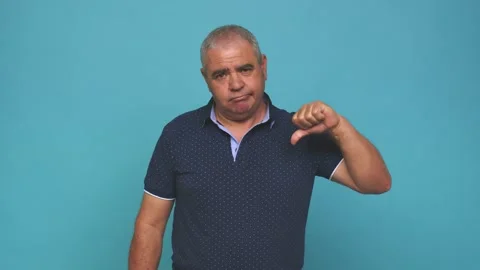 Senior man showing a dislike gesture, thumbs down, disagreement concept Stock Footage 144217841