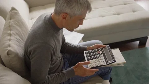 Senior man sighing while calculating expenses Video stock 133528845