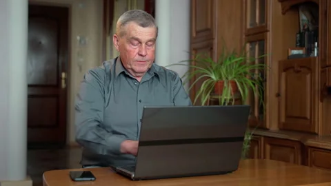 Senior man sit at table look at laptop screen typing read text makes correction Stock Footage 152731547
