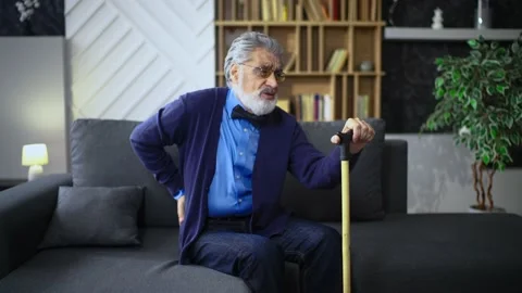 Senior man sits with a cane, his back hurts Stock Footage 236167028