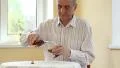 Senior man sits at the table and pours brandy in glass HD Footage