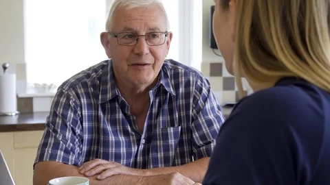 Senior Man Sitting In Kitchen Talking With Woman At Home Stock Footage 109618391
