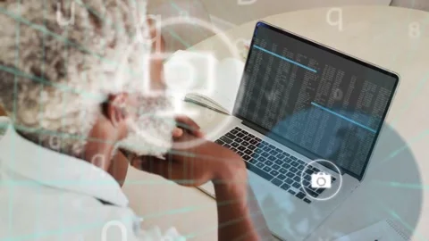 Senior man sitting at laptop, code output activating overlaying phone chat icons Stock Footage 333950448