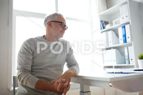 Senior man sitting at medical office table Stock Photos