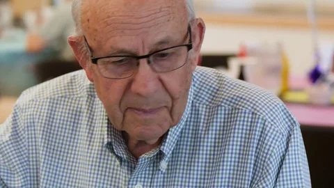 Senior Man Sitting At A Party Table And Talking Stockbeeldmateriaal 76134309