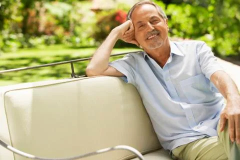 Senior Man Sitting On Sofa In Backyard Stock Photos