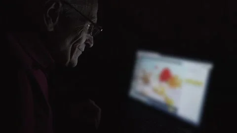 Senior man sitting at table at home and watching summer images Video stock 167799209