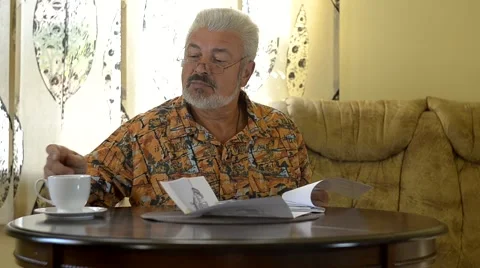 Senior man sitting at table working out bills Stock Footage 43377702