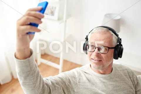 Senior man with smartphone and headphones Stock Photos