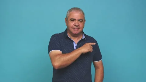 Senior man smiling and pointing aside, showing something at blank space Stock Footage 144217560
