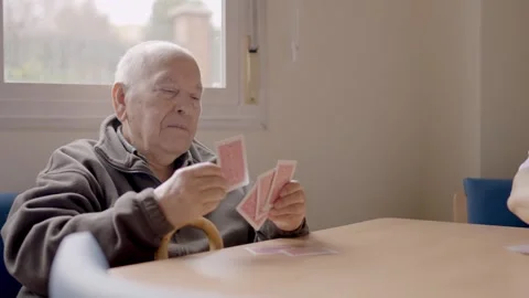 Senior man sorting cards ready to play in a geriatric Stock Footage 270401467