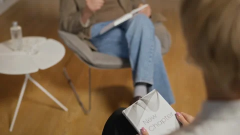 Senior Man Speaking at Book Launch with Woman Holding New Chapter Stock Footage 338046739