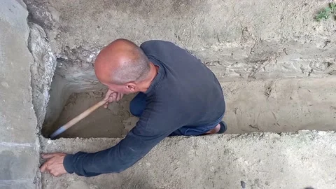 Senior man spreading fluid cement in gutter - From above elderly male spreadi Stock-Footage 204744731