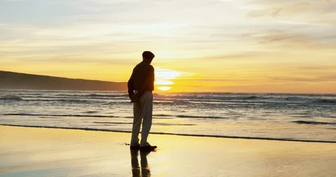 Senior man standing on the beach at sunset. 스톡 동영상 88374079