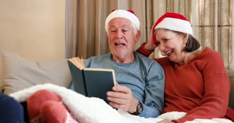 Senior man starting reading book for holiday joy, woman leaning, binary overlay Stock Footage 321734534