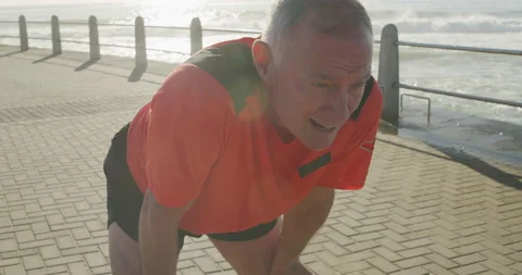 Senior man taking a break from running on the promenade Stock Footage 135455292